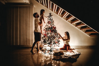 A family joyfully decorating their Nordmann Christmas tree.
