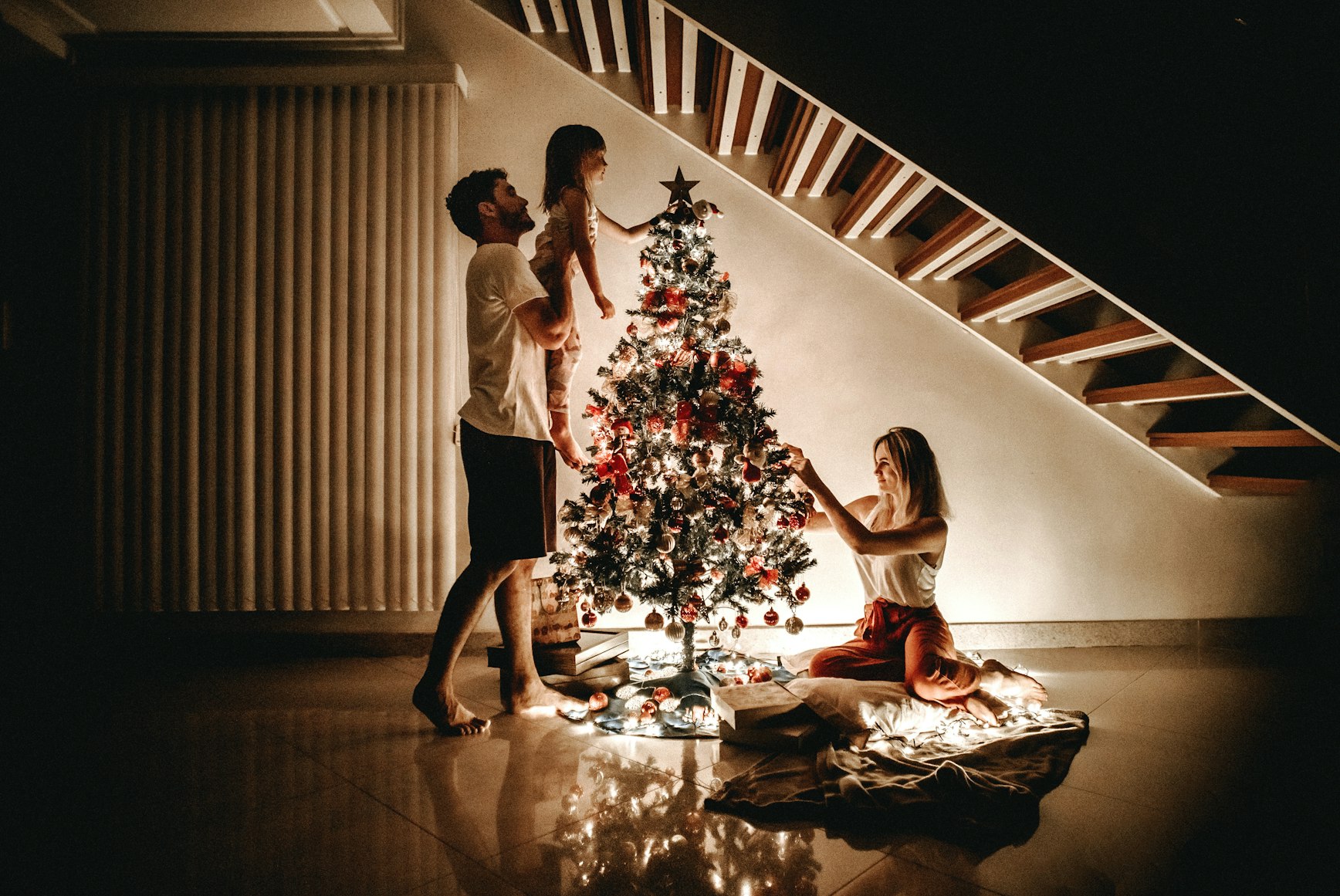 Family decorating a tree for the holidays.