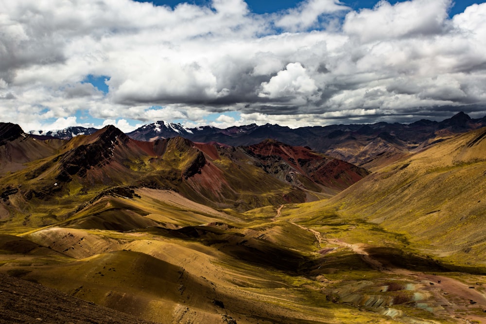 rocky mountain under cloudy blue sky during daytime