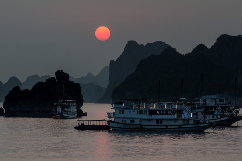 Ha Long Bay's Limestone Karsts white ship on calm water during golden hour