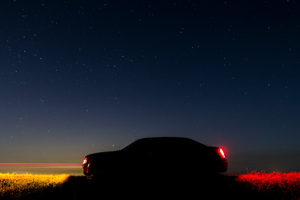 silhouette of car under starry sky during nighttime