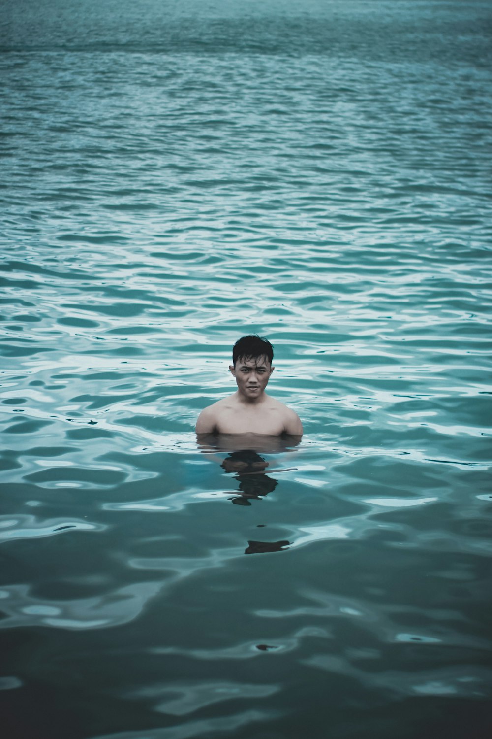 man bathing on calm water