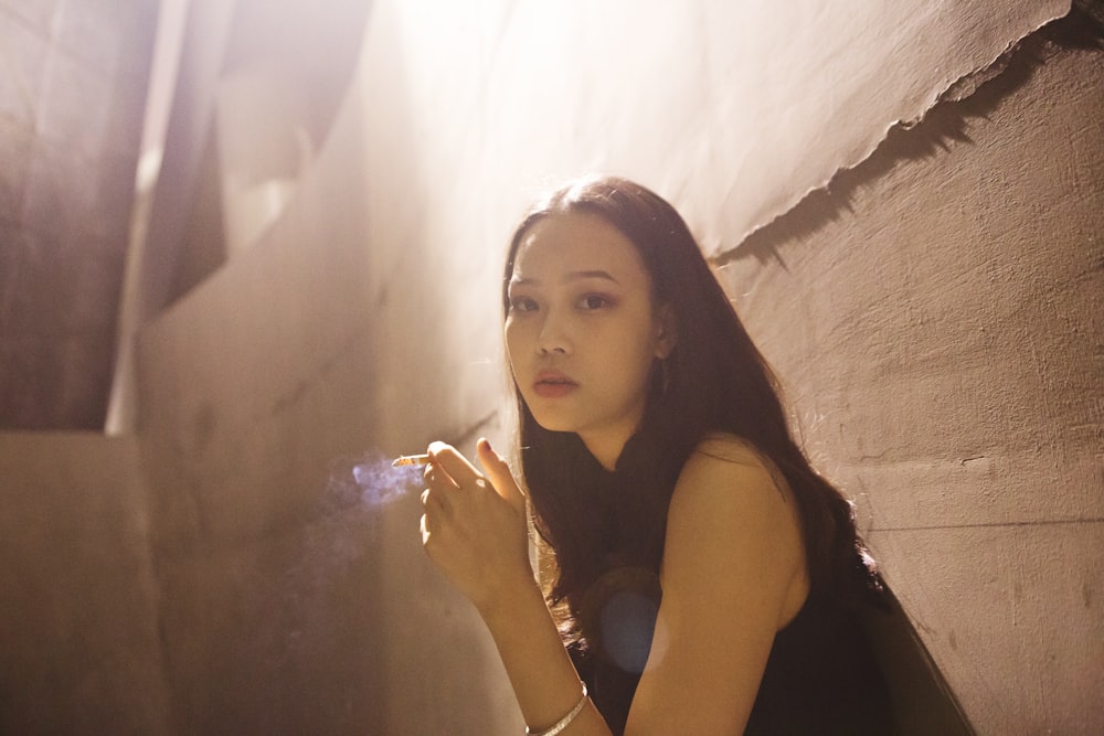 woman wearing black sleeveless top beside wall