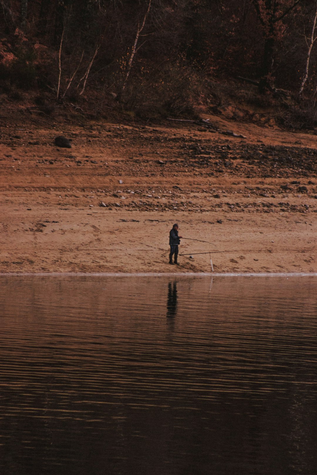 man holding rod fishing on water