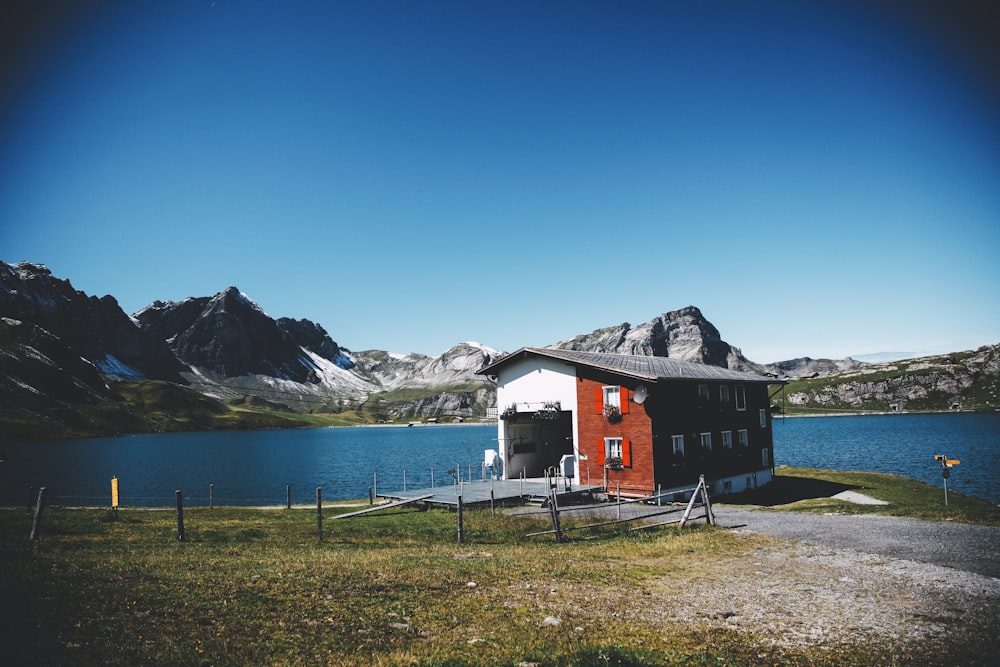 brown concrete house beside blue body of water