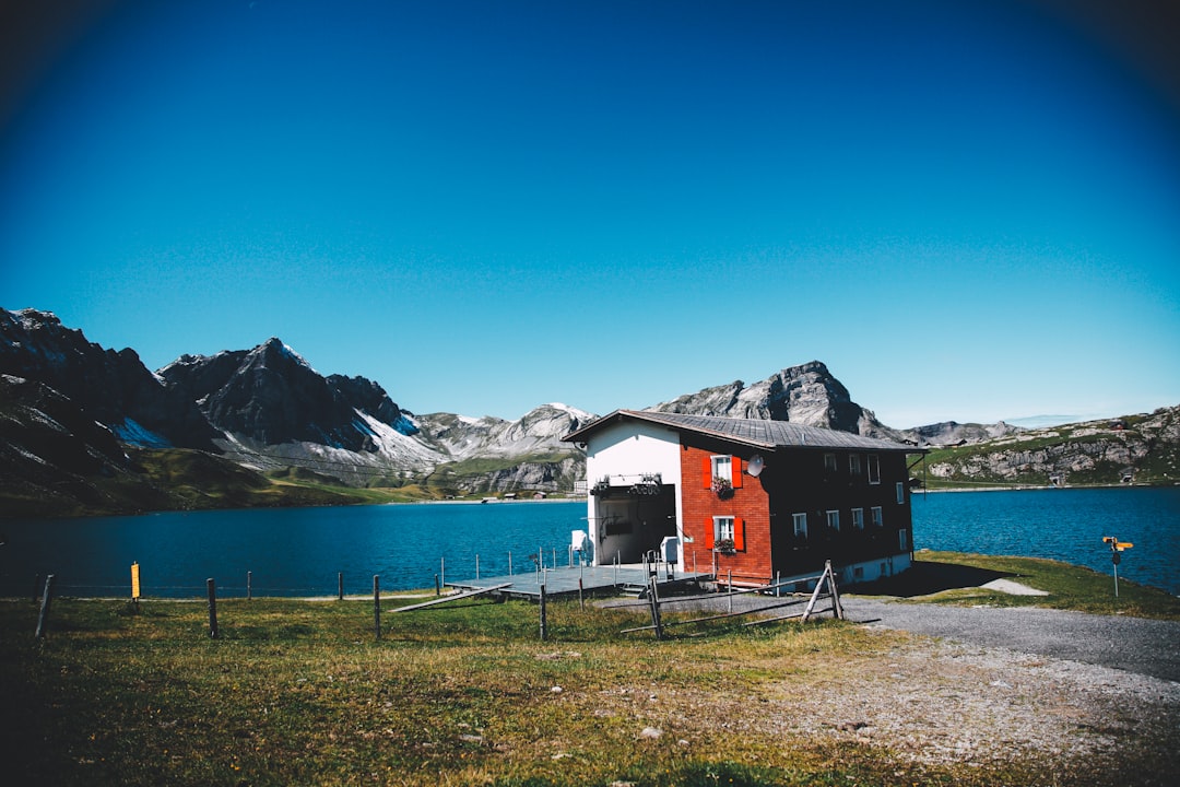 brown concrete house beside blue body of water