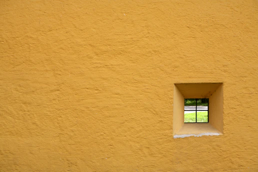 glass window pane with yellow concrete wall
