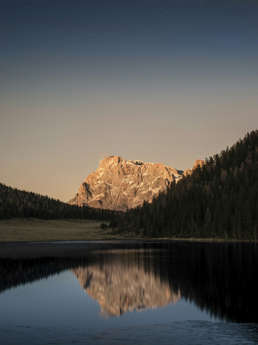 reflection of mountain on body of water