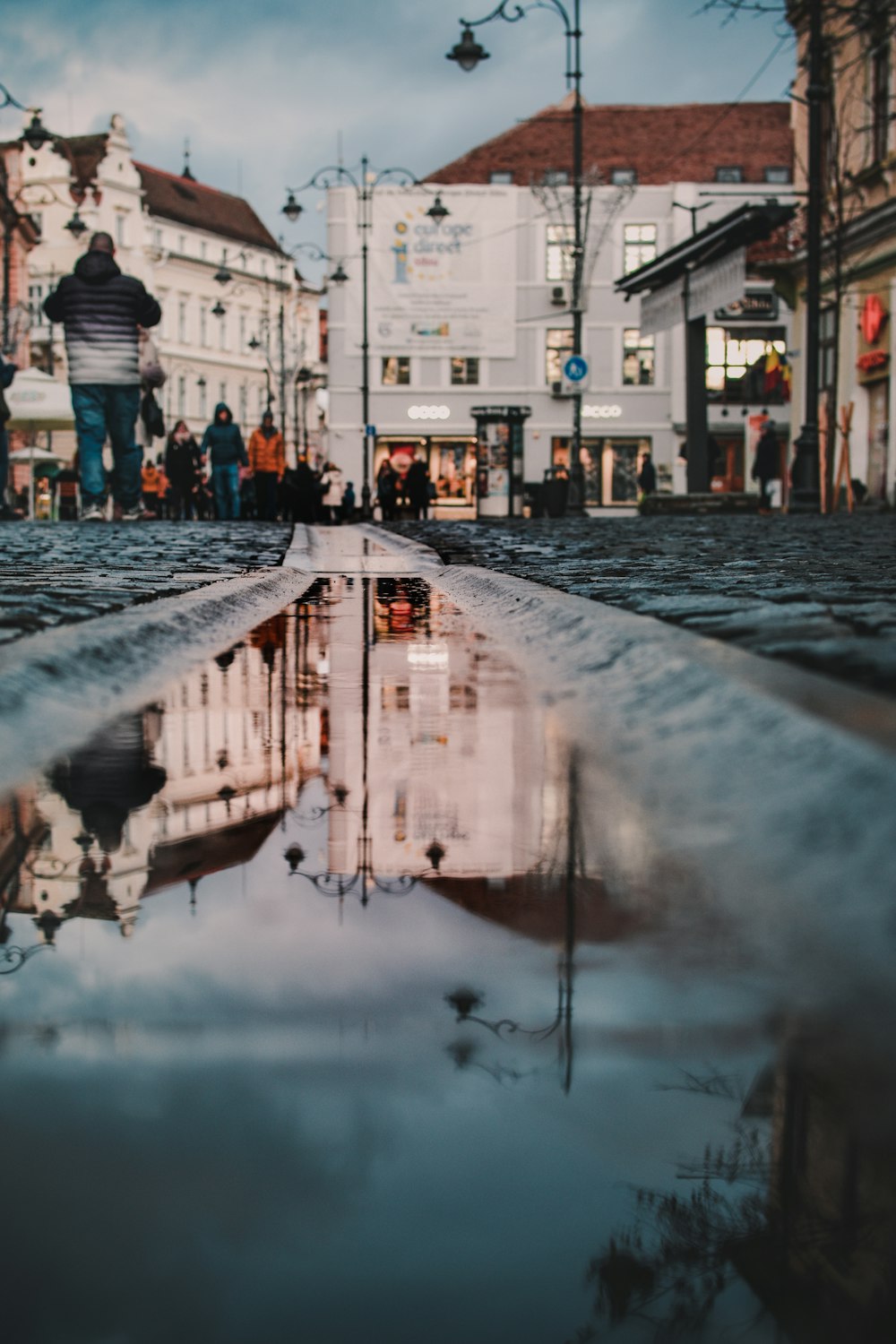 a reflection of a building in a puddle