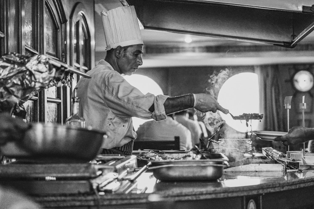 grayscale photo of man cooking