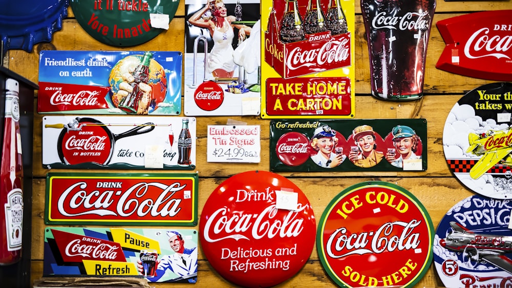 lotto assortito di adesivi Coca Cola sul muro