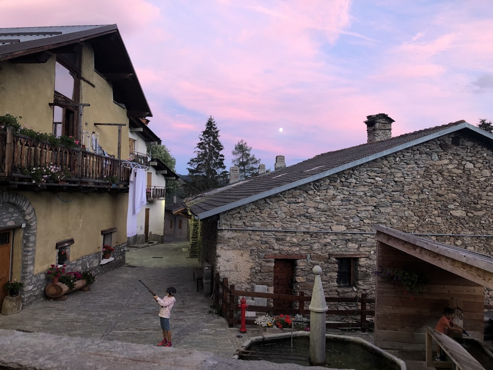 child standing on pathway between houses