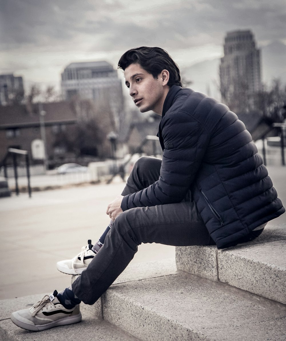 man sitting on concrete surface