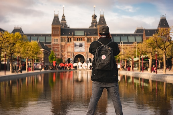 man standing in front pond