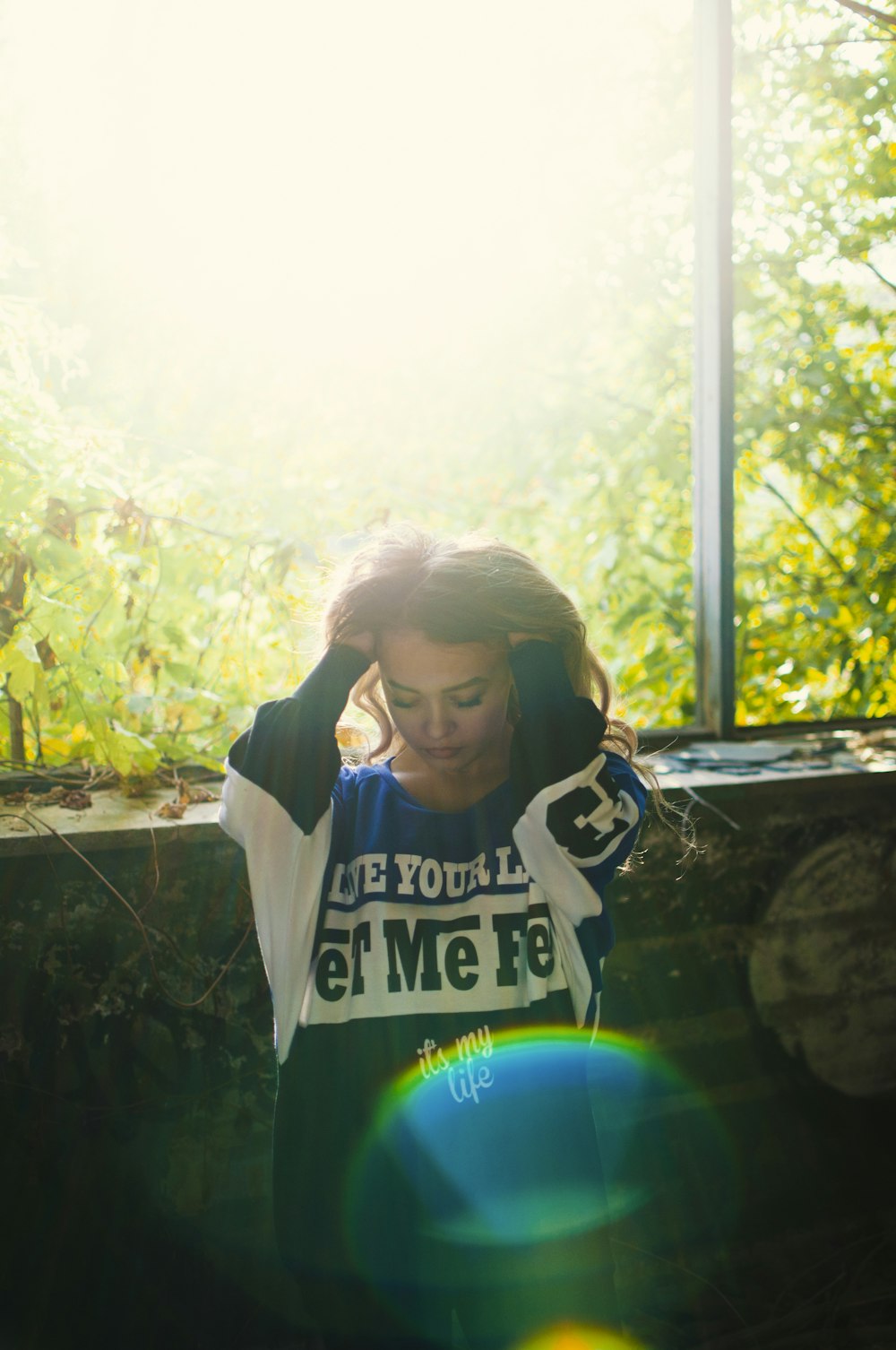 woman wearing sweatshirt while standing near concrete wall