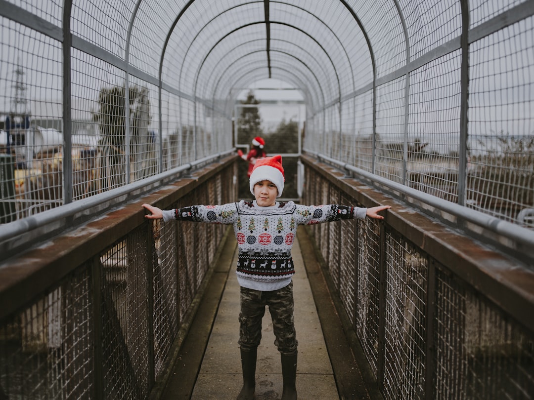 boy standing on brown metal bridge