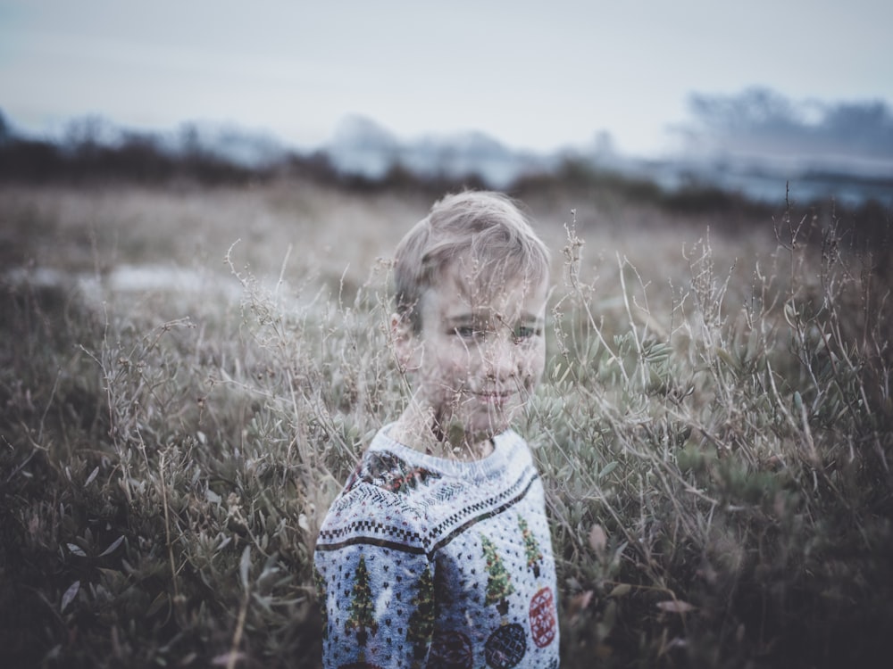 boy standing near grasses