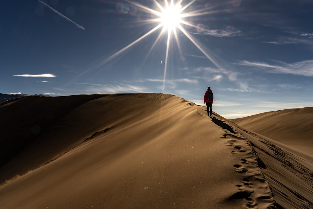 man walking on top of brown dessert