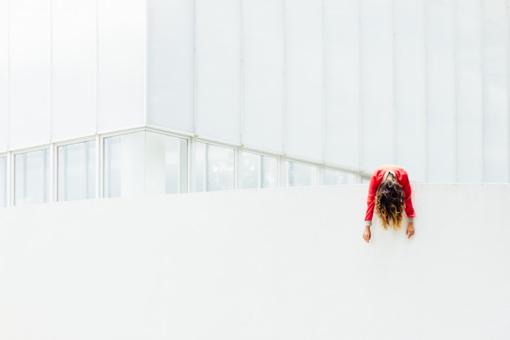 woman in red jacket on white painted concrete railings