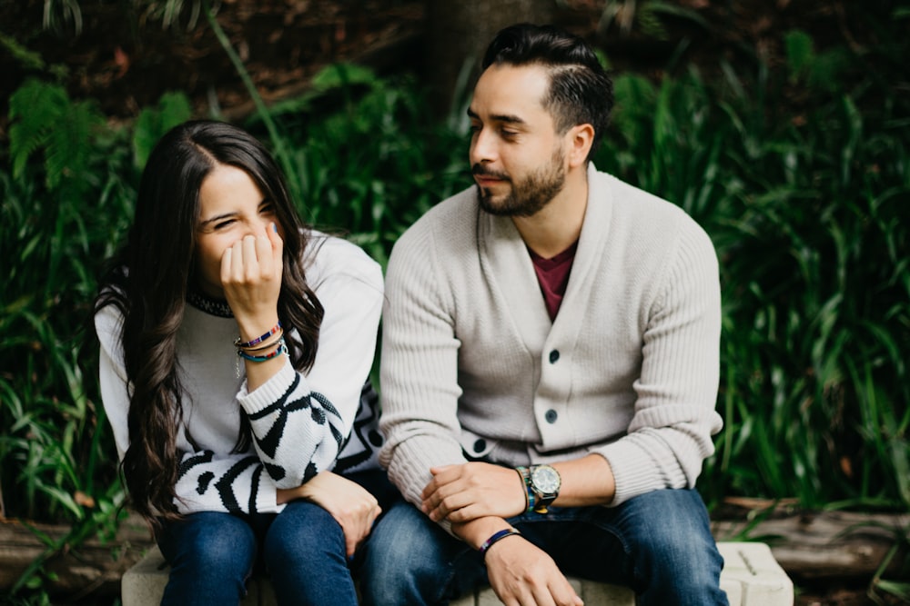 man sitting beside smiling woman