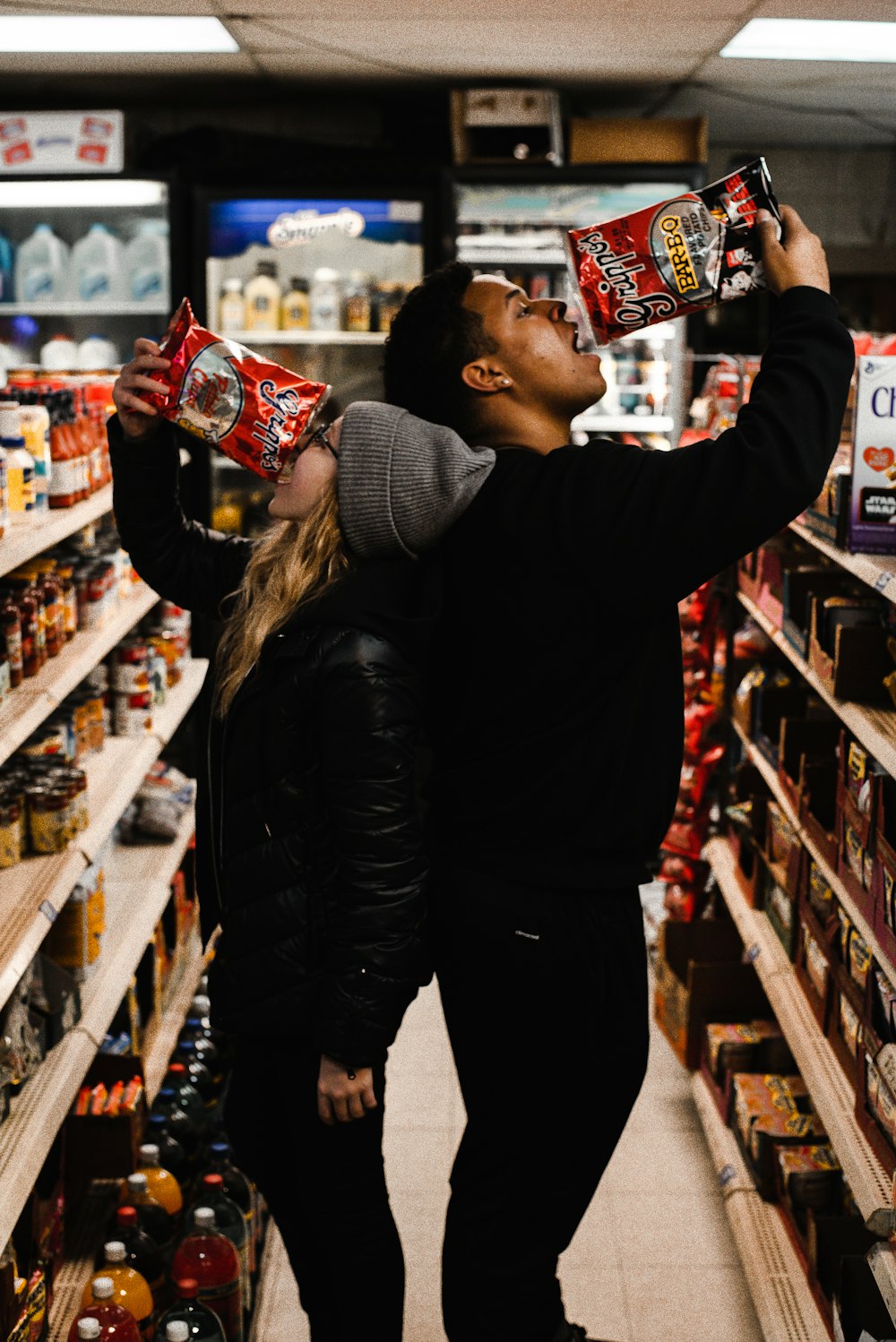 man and woman eating chips in shallow photo