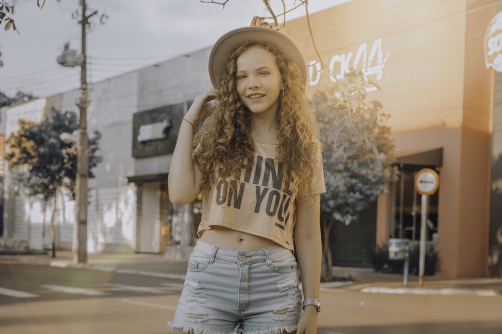 woman in crop top and denim shorts standing near storefront