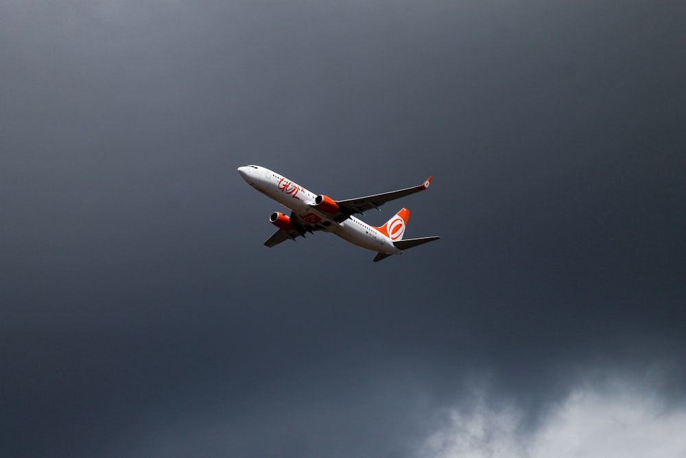 Avión naranja y blanco en vuelo
