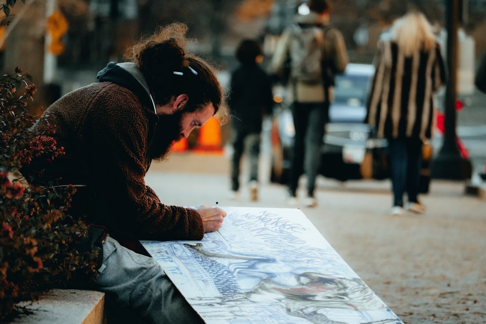 man painting beside plants