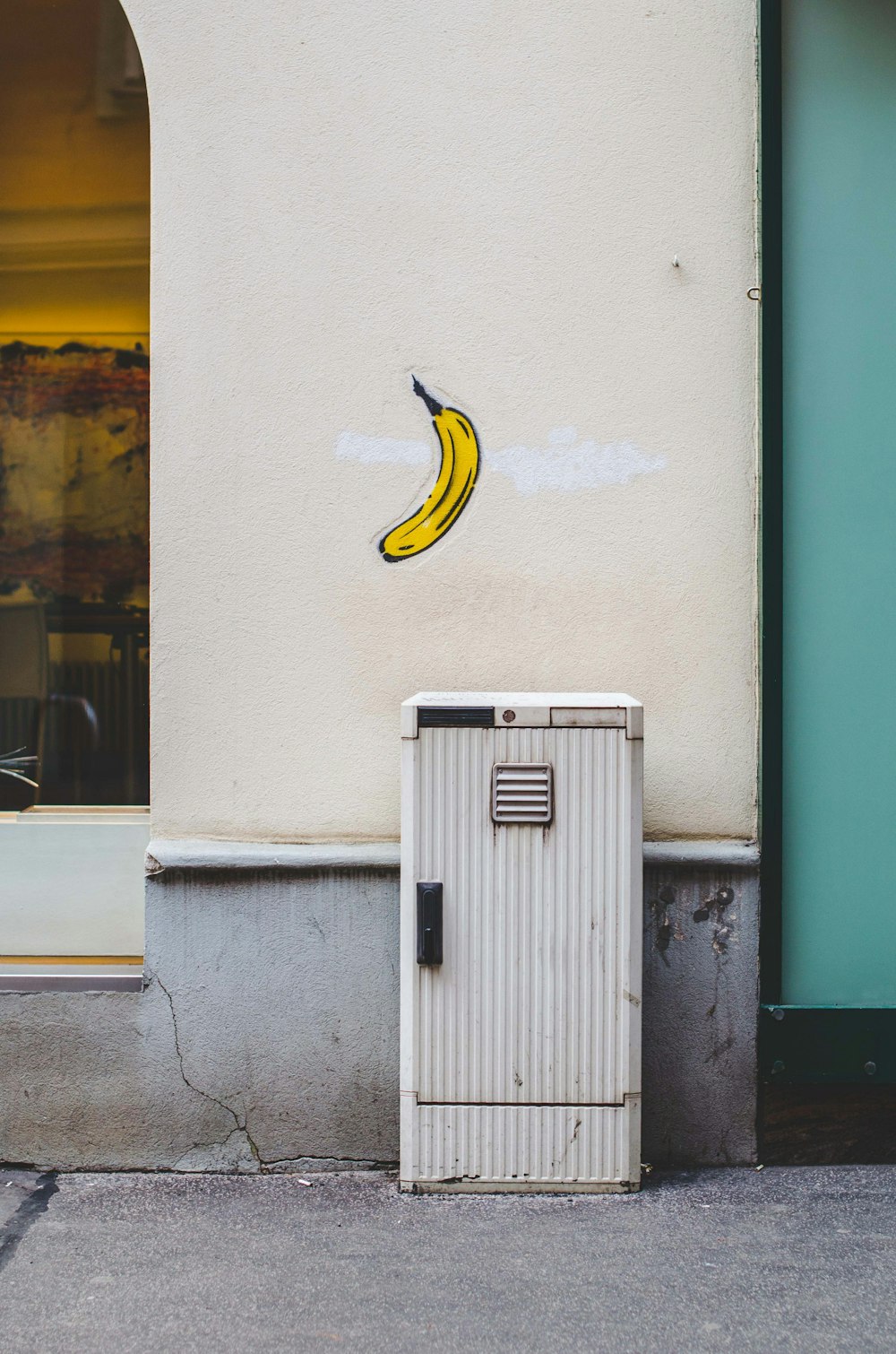 Boîte aux lettres blanche près du mur avec peinture de fruits de banane