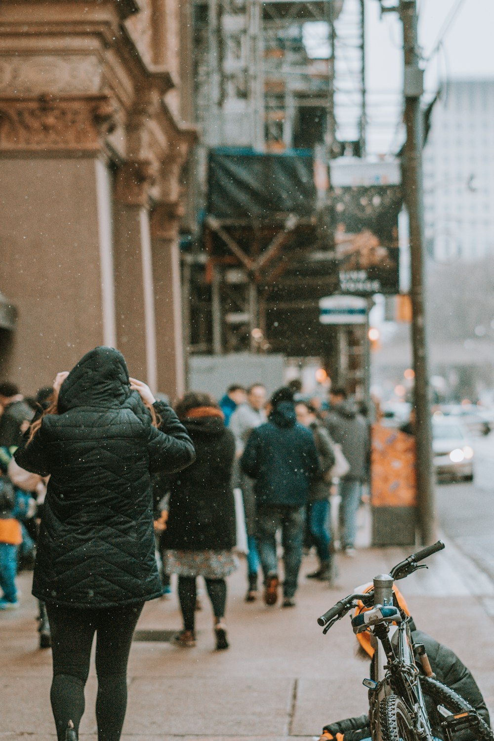 person walking on street beside bike