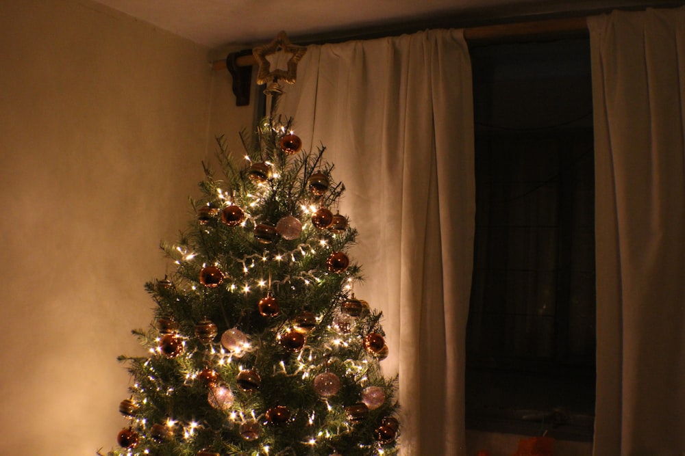 Christmas tree beside panel curtain