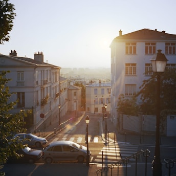 A serene sunrise over a quiet Parisian street bathed in soft beige and gold light.