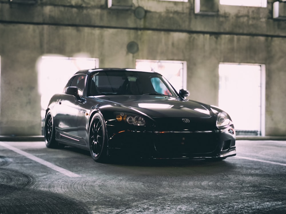 black Honda coupe parked inside building