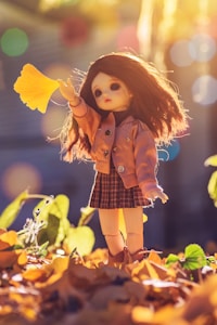 doll standing on brown leaves