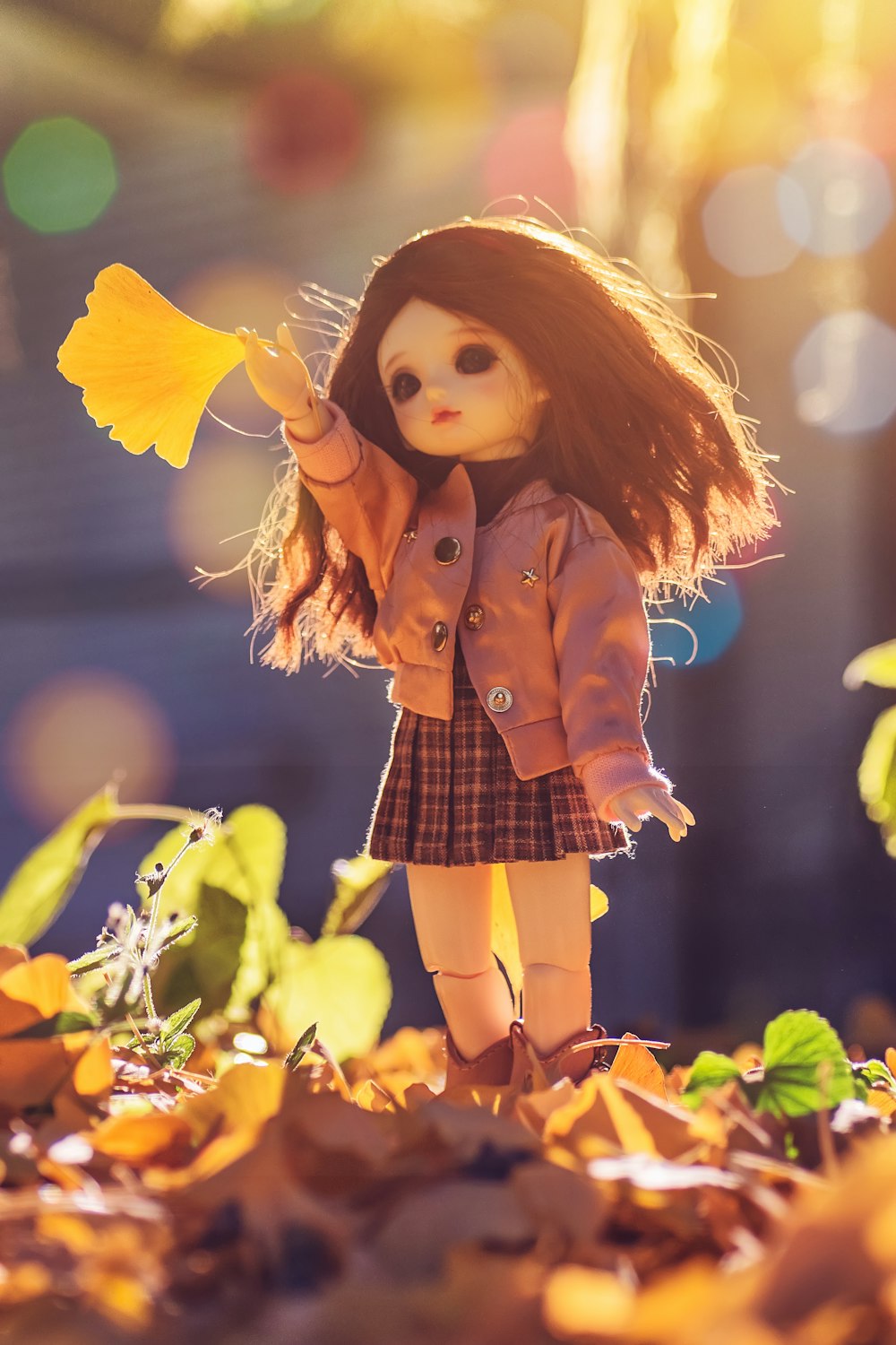 muñeca de pie sobre hojas marrones