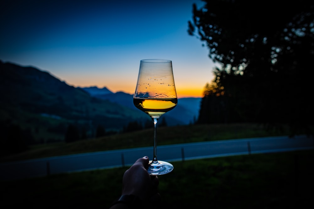 Verre à vin à long pied rempli d’un liquide clair