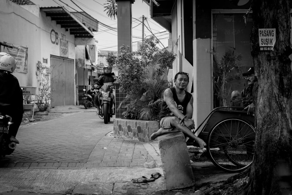 man sitting beside bike