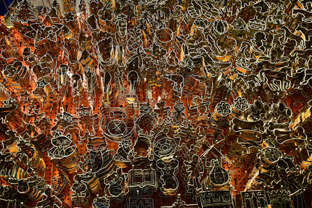 Close-up of colorful 3D-printed cookie cutters and cake decorating tools on a wooden table.