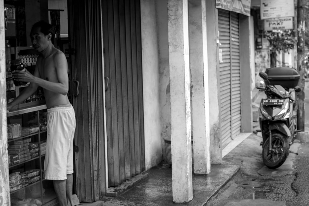 grayscale photography of half naked man at store