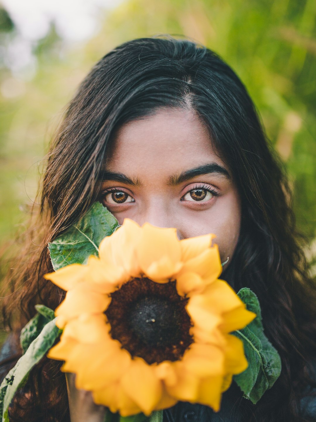 selective focus photography of woman holding sunflower