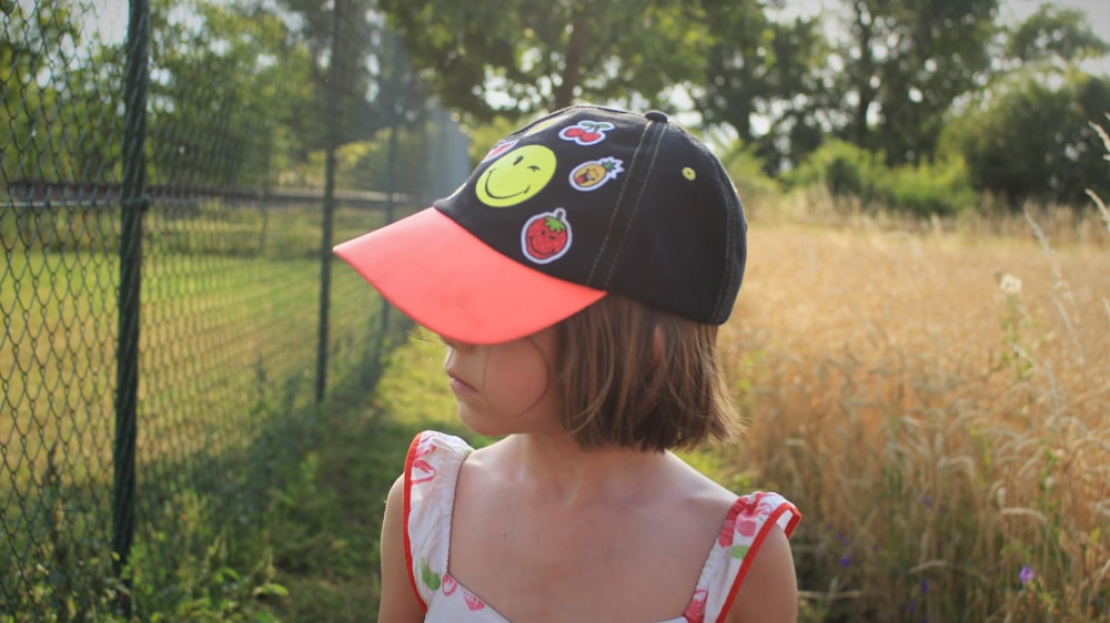 girl wearing baseball cap standing outdoor