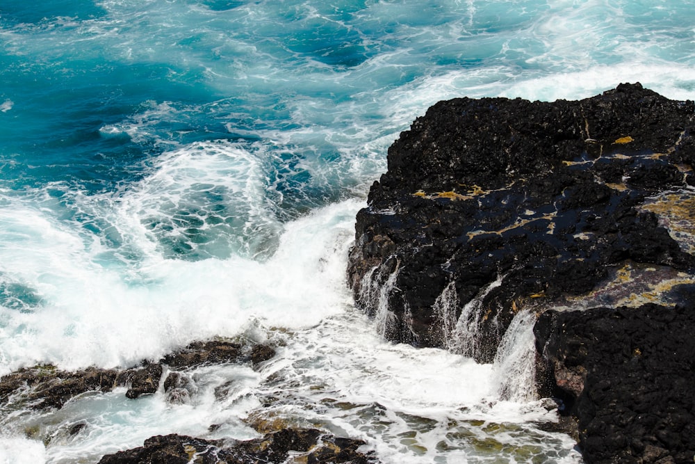 waves crashing coastal rock during daytime