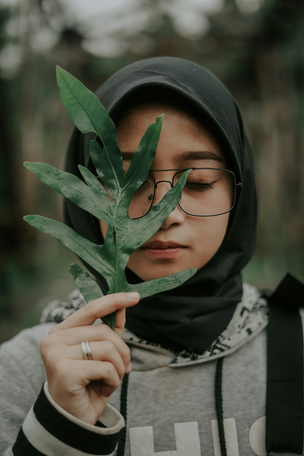 녹색 잎을 들고 히잡을 쓴 여자