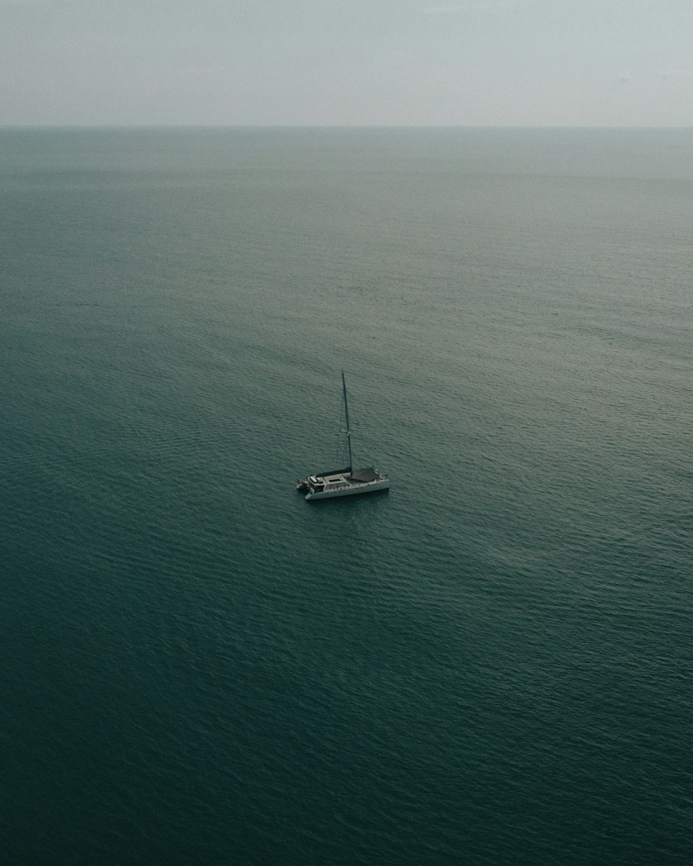 white sailboat at middle of ocean