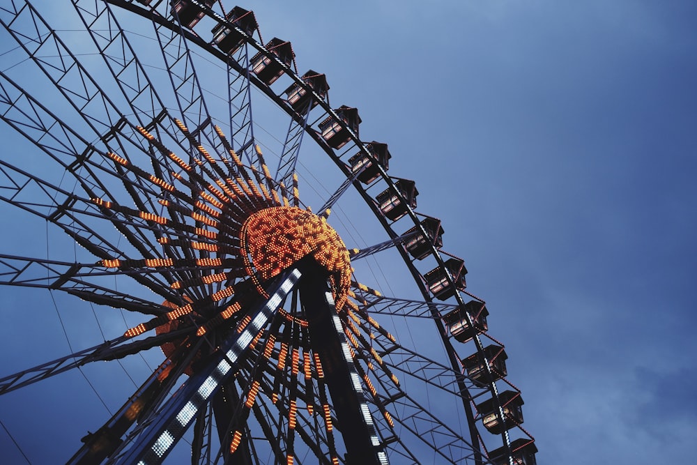 orange and black ferris wheel under blue sky