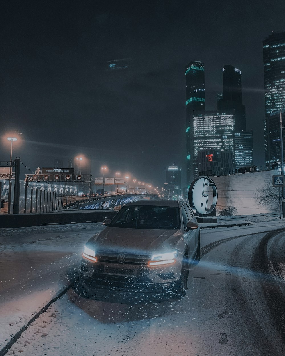 silver SUV passing on road beside turned on post lamps during night