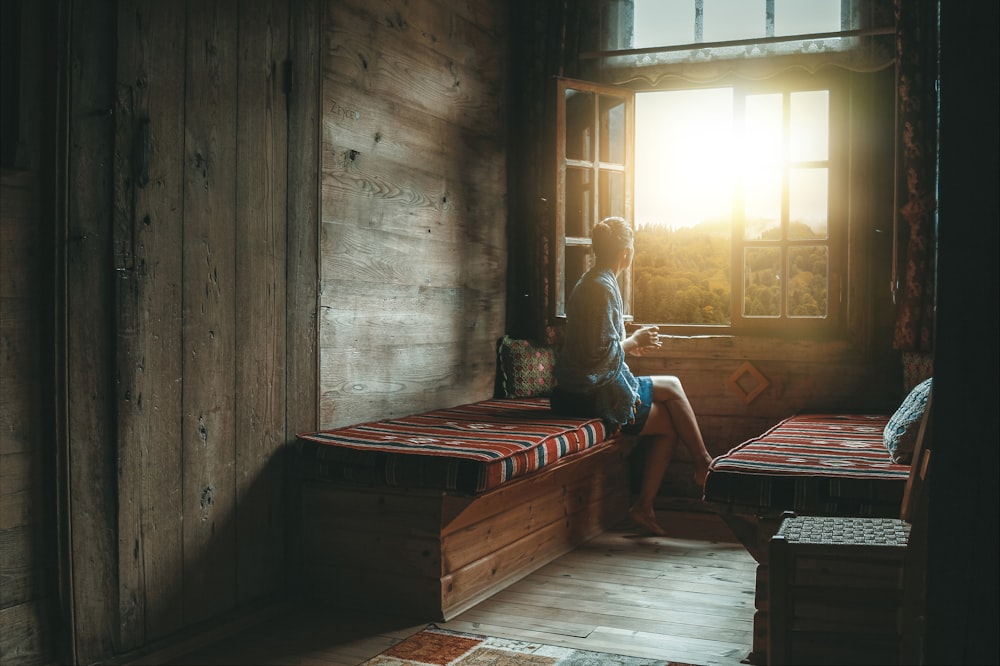 Mujer sentada al lado de la ventana