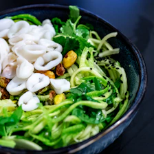 A colorful bowl of mixed seaweed salad featuring vibrant greens and textures.