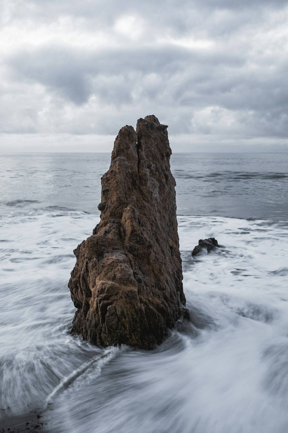 brown rock on body of water across horizon