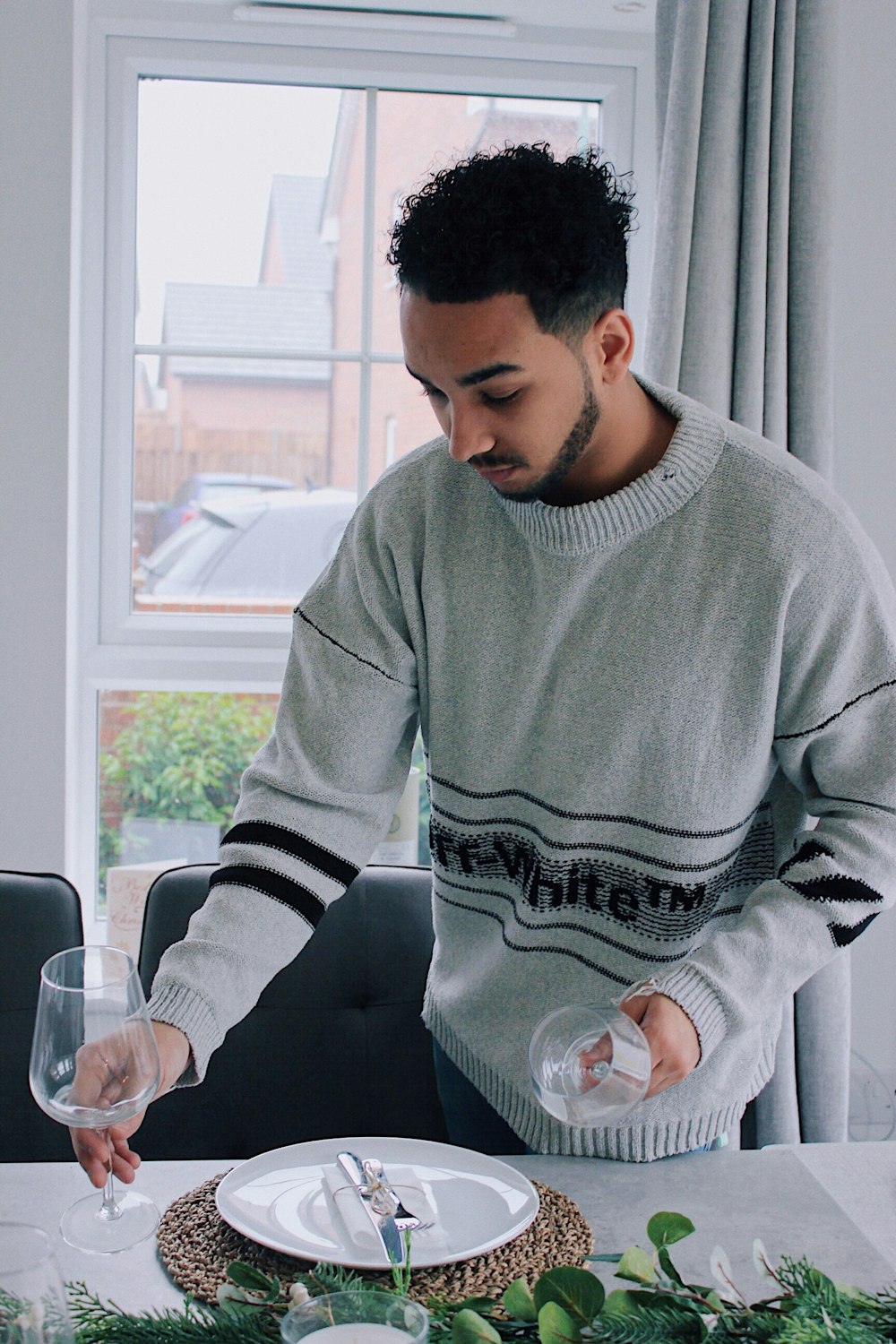 man holding clear glass goblet glass